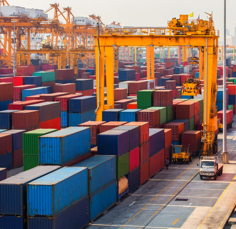 Container yard with gantry cranes and stacked freight containers.
