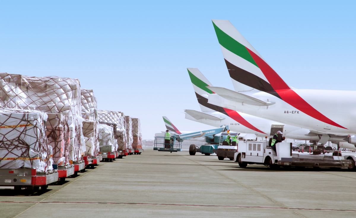 Air cargo pallets prepared beside aircraft at an international airport apron.